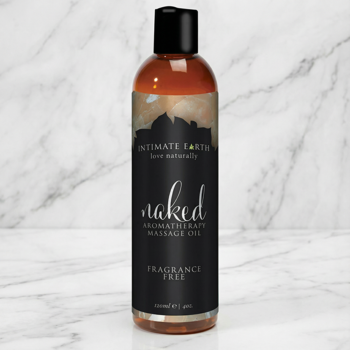 Fles Naked geurvrije massageolie met amberkleurige olie op een marmeren plank, Intimate Earth