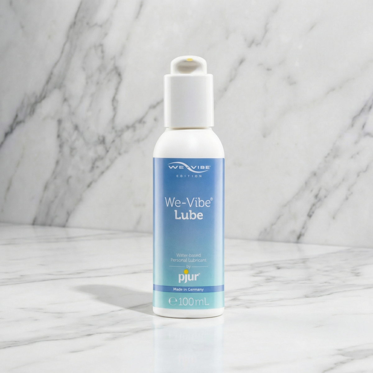 Fles We-Vibe Lube van pjur met wit pompje op een marmeren plank, 100 ml glijmiddel op waterbasis