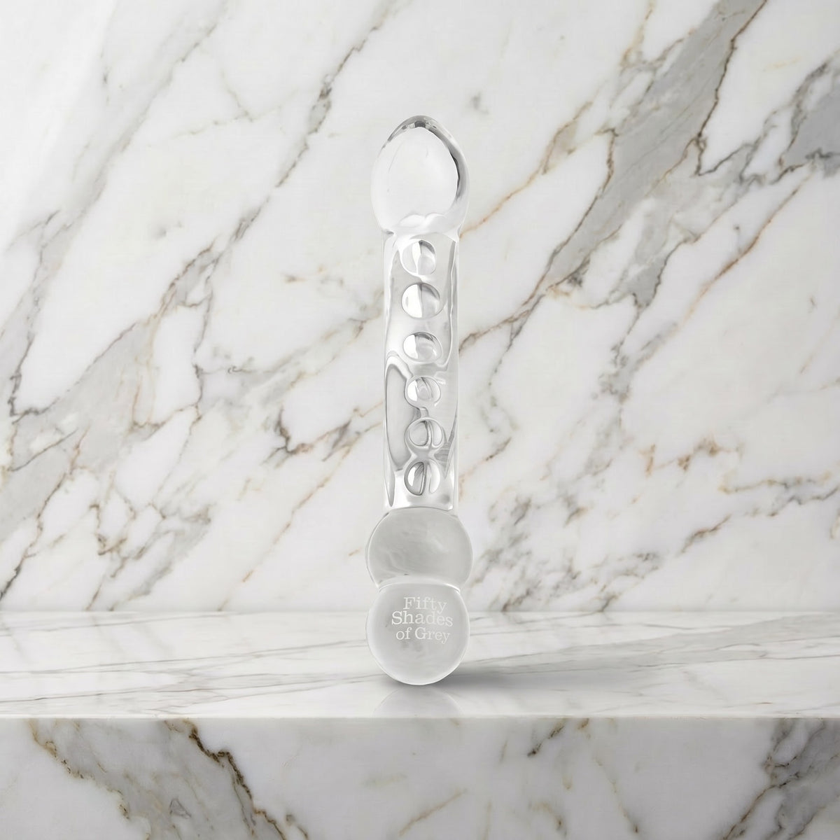 Gebogen glazen dildo Drive Me Crazy met knobbeltjes rechtop op een marmeren plank