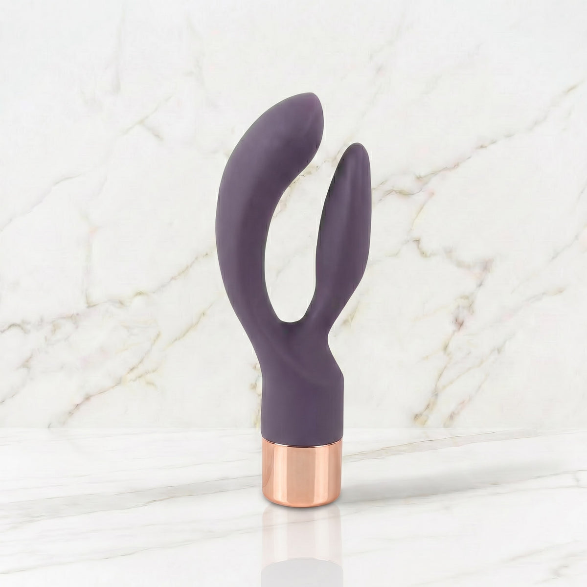 Slanke donkerpaarse rabbit vibrator met rose gouden kap op een marmeren plank, Elegant