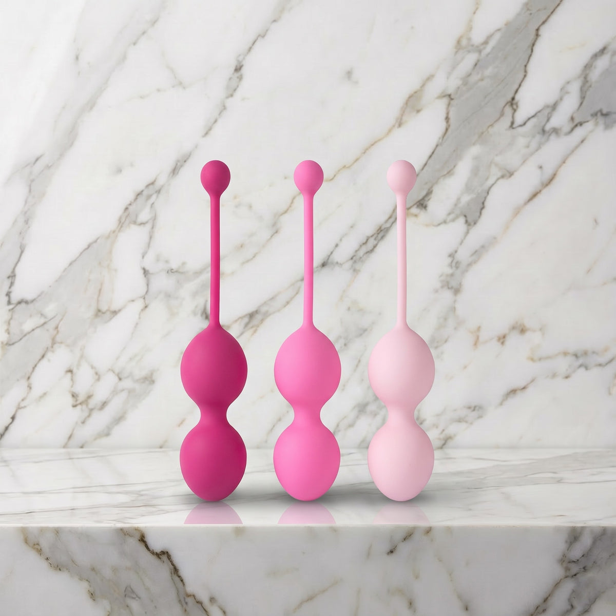 Drie roze dubbele kegels in oplopende tint op een marmeren plank, FemmeFit Advanced