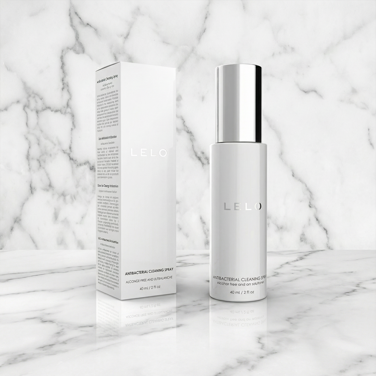 Witte Lelo reinigingsspray met zilveren dop naast de doos op een marmeren plank