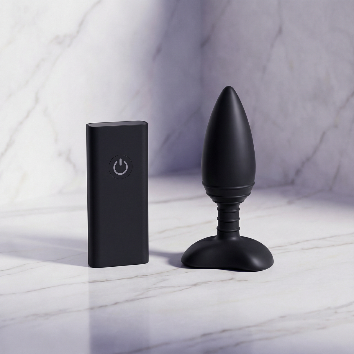 Zwarte Nexus Ace Small vibrerende buttplug met afstandsbediening rechtop op een marmeren plank