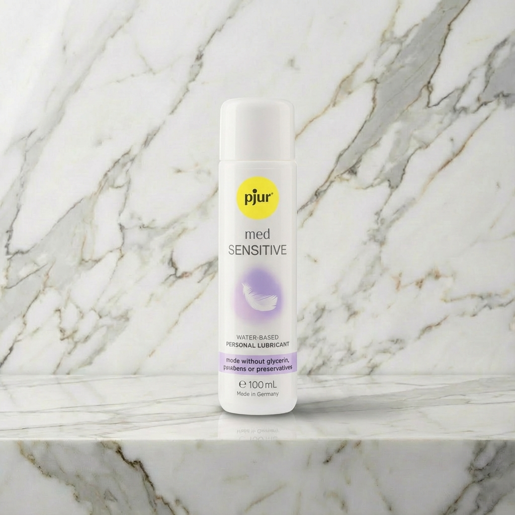 Witte pompflacon pjur med Sensitive glijmiddel op waterbasis op een marmeren plank