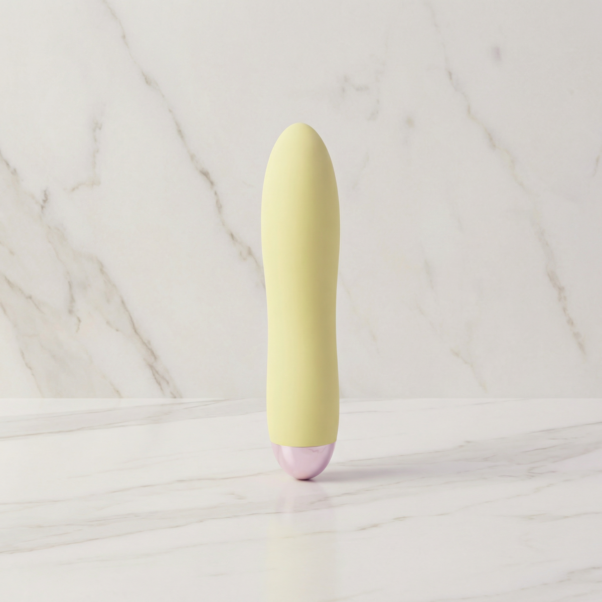 Lichtgele Cuties mini vibrator rechtop op een marmeren plank