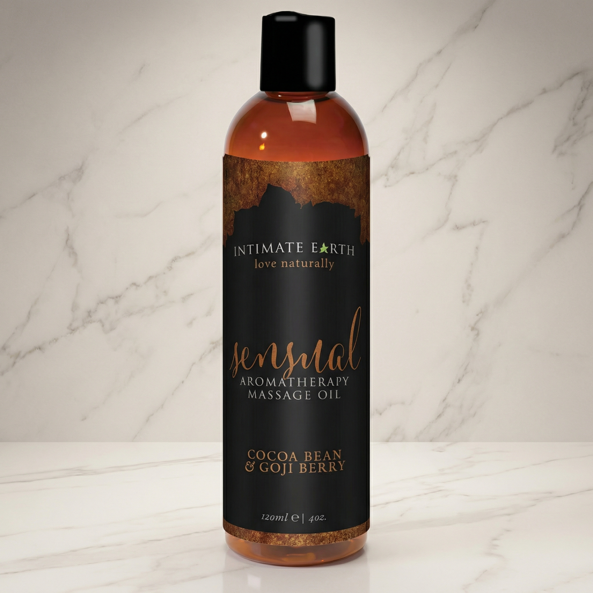 Bruine fles Sensual massageolie met zwart etiket op een marmeren plank, Intimate Earth