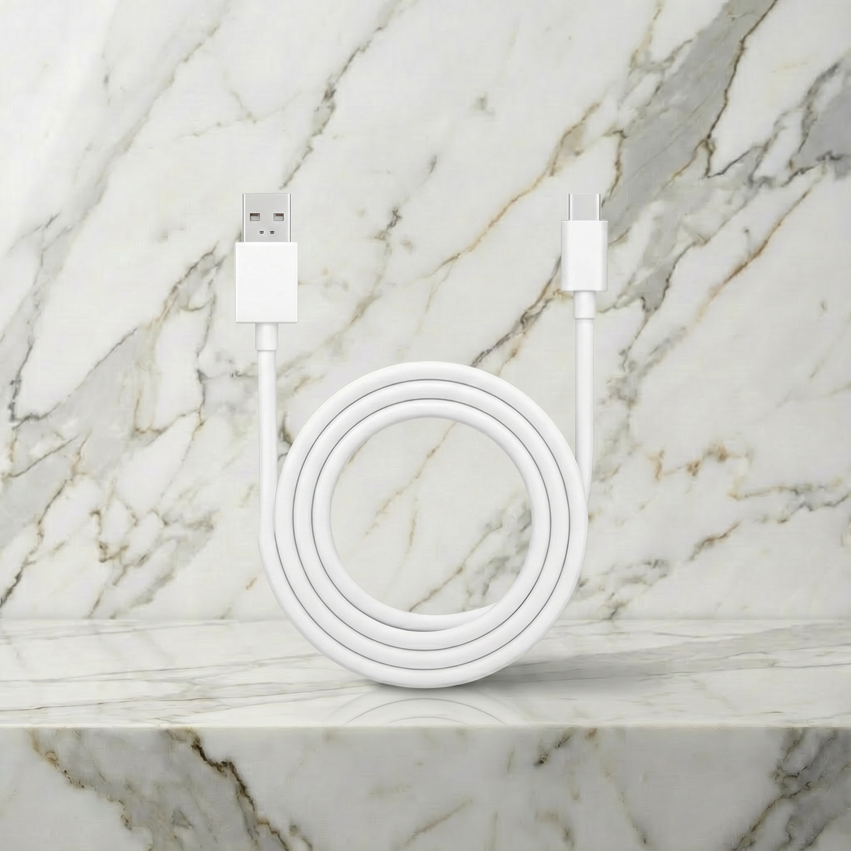 Losse witte USB-oplaadkabel voor een vibrator, opgerold op een marmeren plank