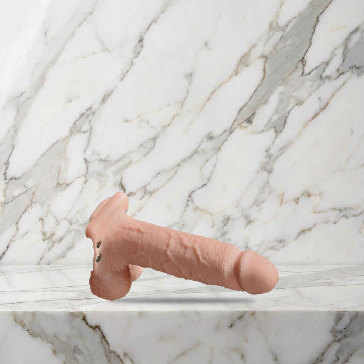 Donkerbeige holle strap-on met vibratie liggend op een marmeren plank, maat M