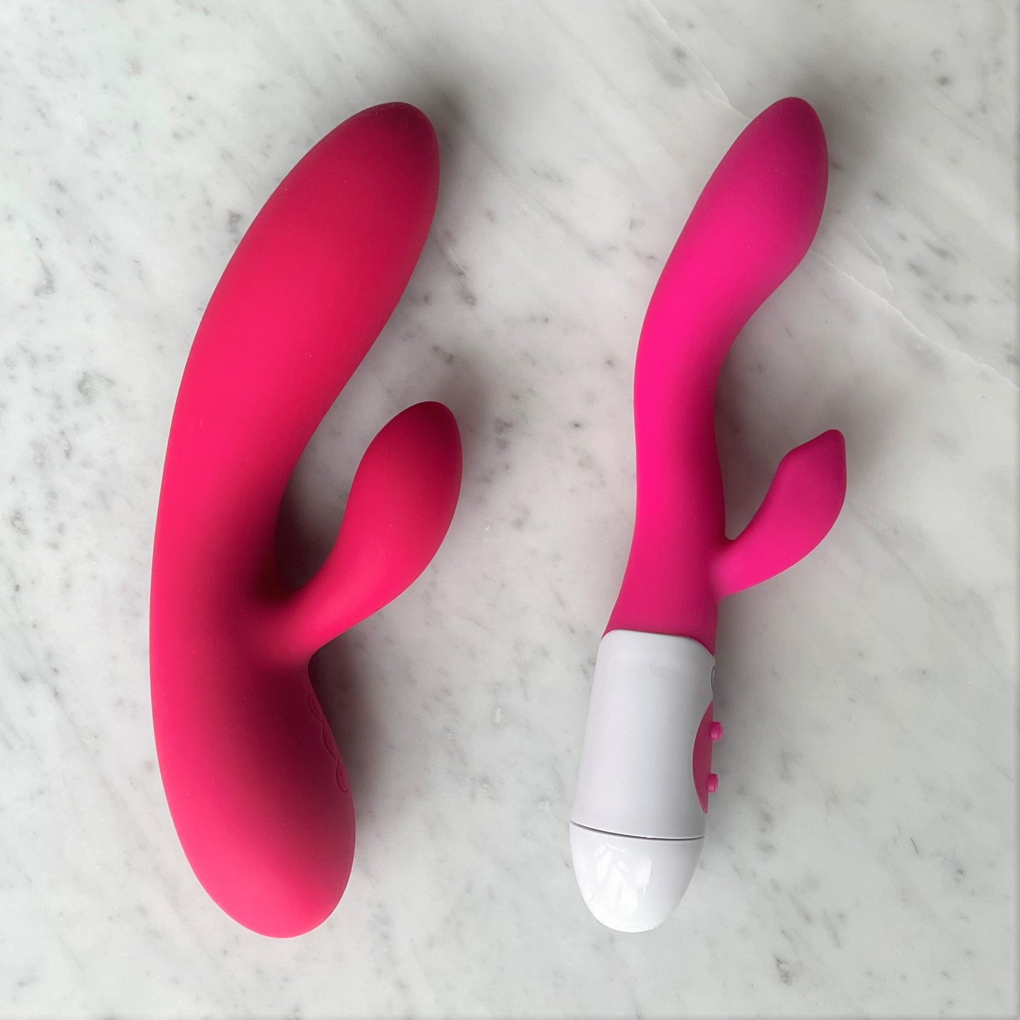 Lily Vibe Easy Toys rabbit vibrator in roze siliconen naast vergelijkbaar model op marmeren ondergrond