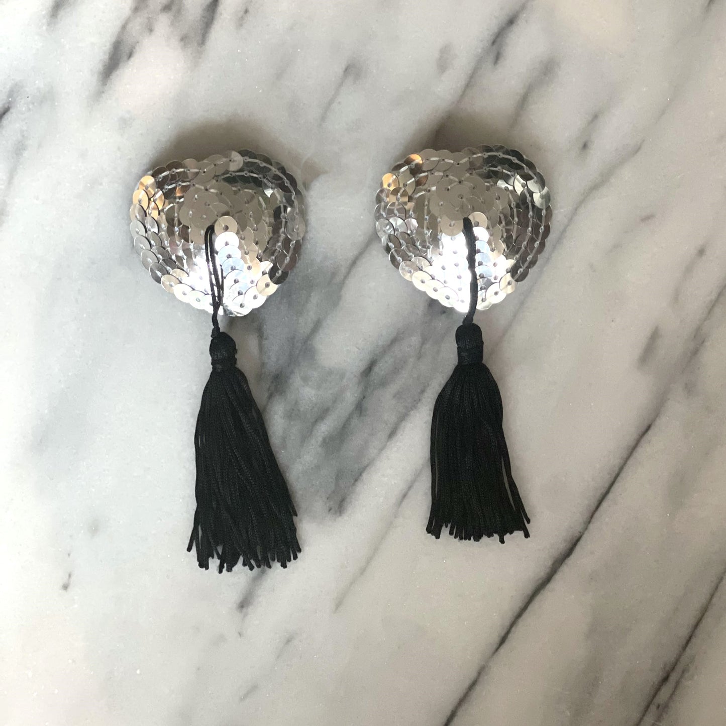 Zilver-gouden tepelkwastjes van De Paarse Keizerin op witte achtergrond