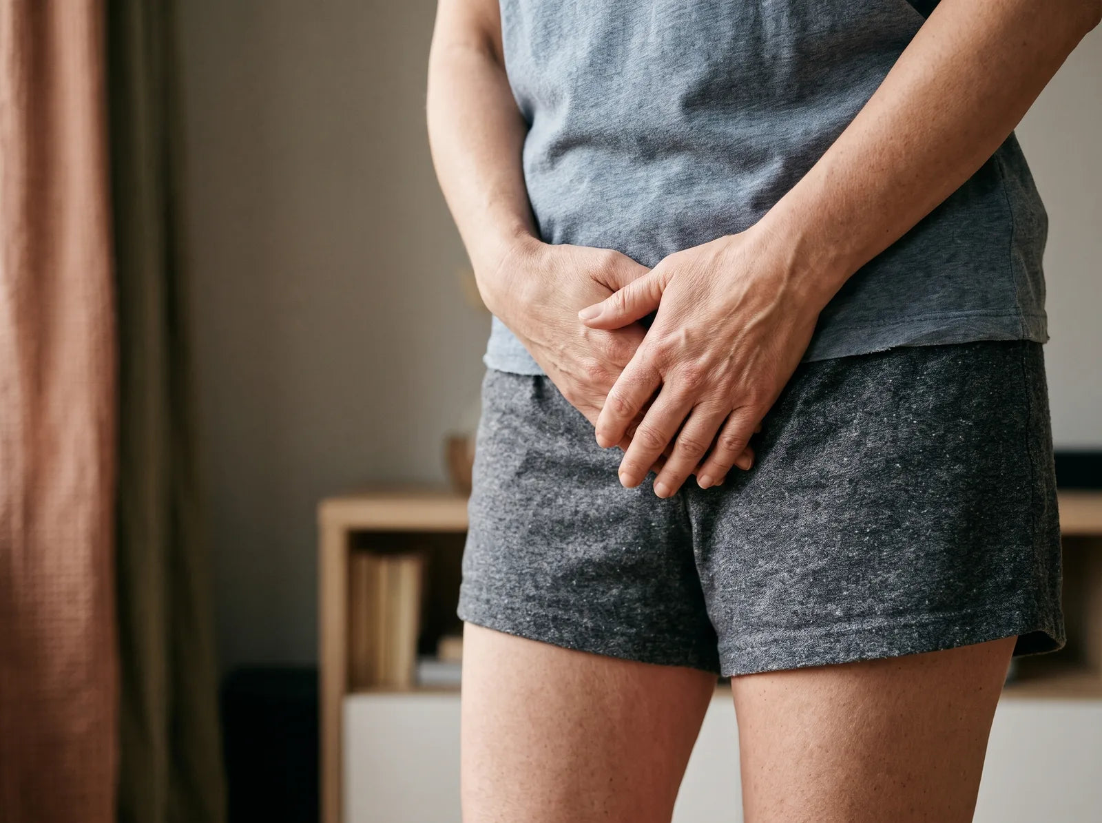 Sfeerbeeld: een vrouw van middelbare leeftijd houdt haar handen op haar onderbuik, zonder gezicht