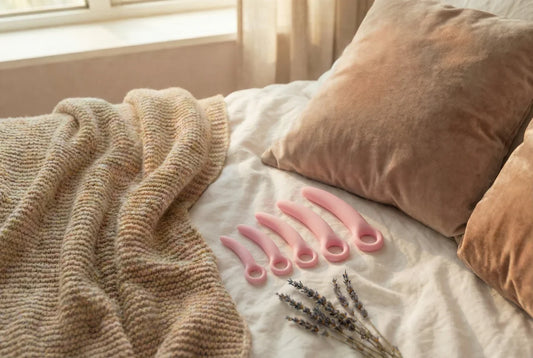 Set van roze vaginale dilators in oplopende maat op bed met lavendel