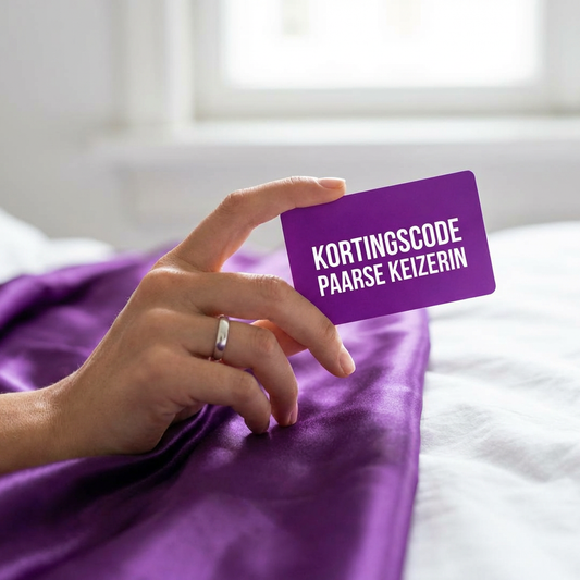 Hand houdt paarse kortingscode-kaart van De Paarse Keizerin vast op satijnen laken