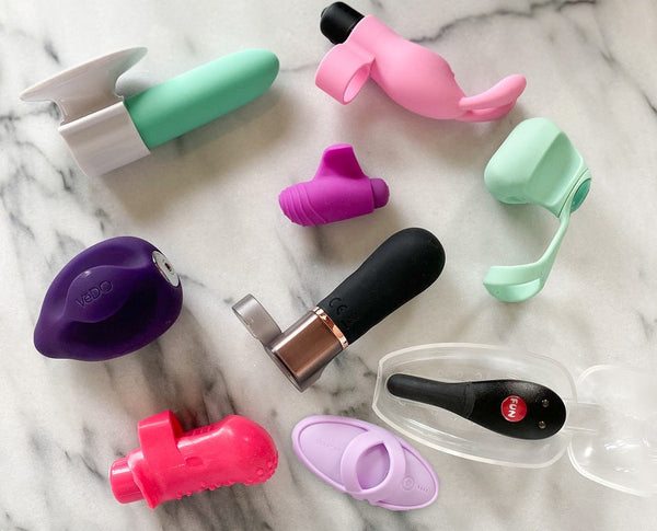 Geteste vingervibrators op wit marmer, met rechtsonder de lila Svakom Echo 2