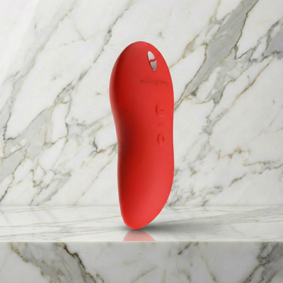 We-Vibe Touch X in oranje, rechtop op marmer