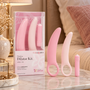 Verpakking van de dilatorset met vibraties naast de twee roze dilators en de bulletvibrator, op een marmeren nachtkastje