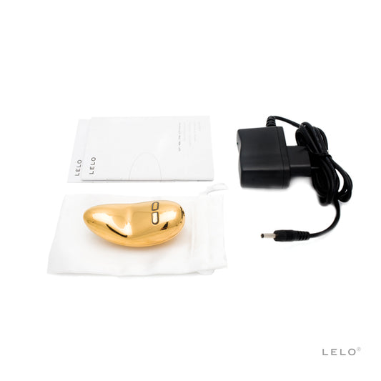 Gouden LELO vibrator met bijgeleverde accessoires: oplader, opbergzakje en handleiding