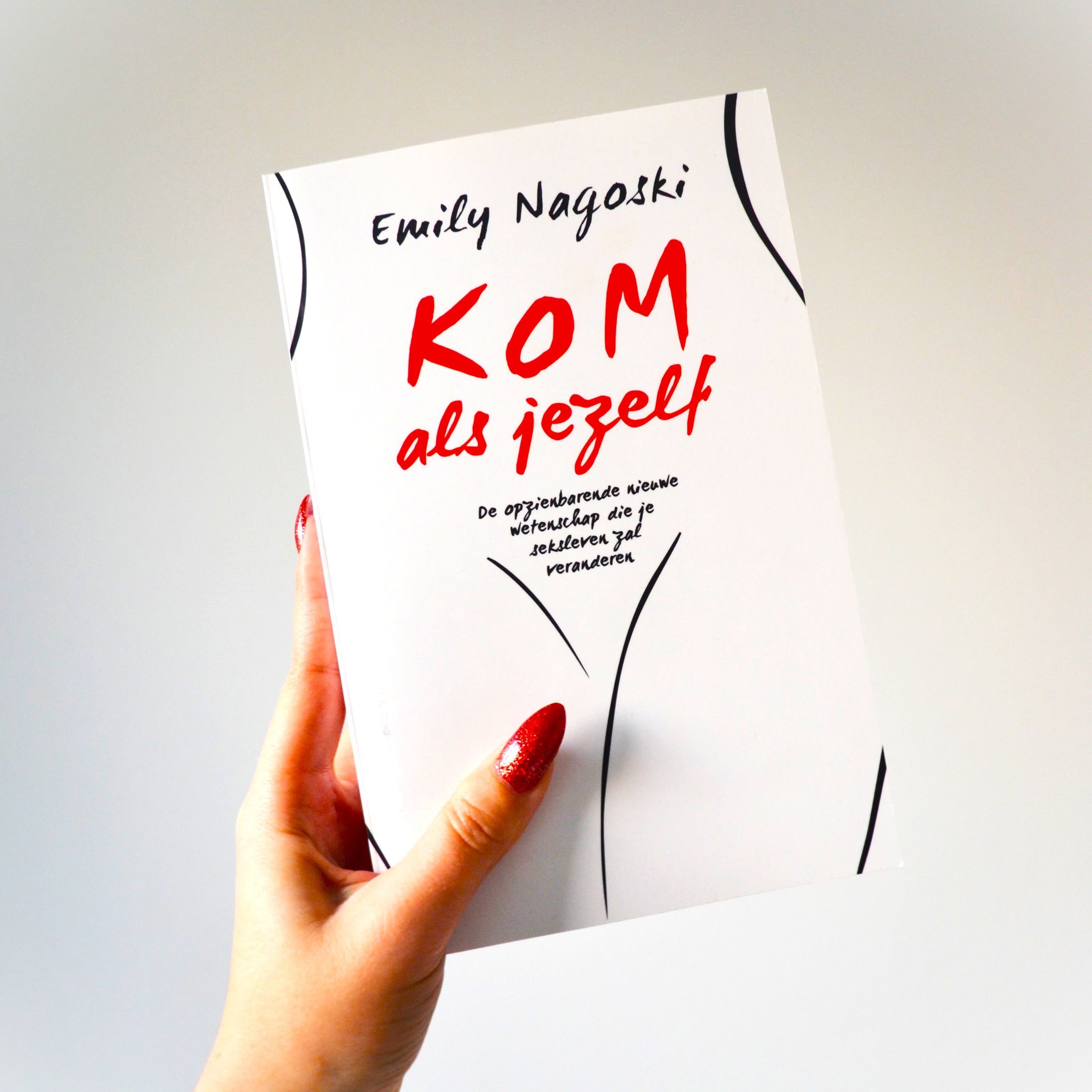Hand houdt het boek Kom als jezelf van Emily Nagoski vast, witte omslag met rode letters