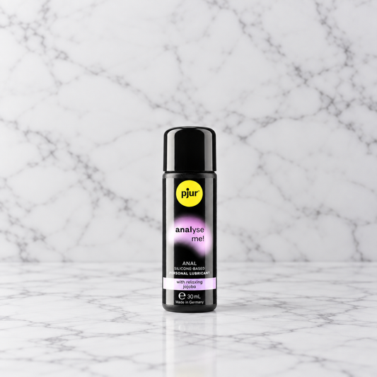 Zwart flesje anaal glijmiddel Analyse Me van 30 ml op een marmeren plank, Pjur