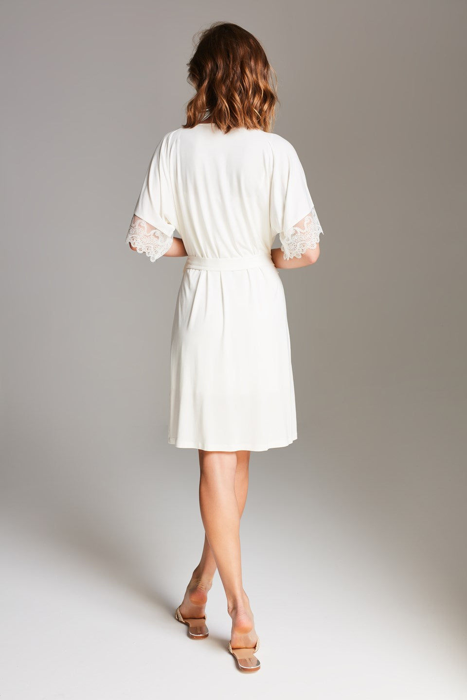 Peignoir van Vanilla in wit, achterkant met ceintuur in de taille en kanten afwerking aan korte mouwen