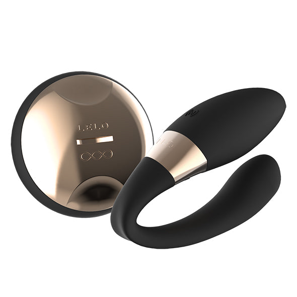 Lelo Tiani Duo koppelvibrator in zwart met gouden accent naast ronde afstandsbediening