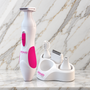 Wit-roze scheerapparaat naast de standaard met opzetstukken op een marmeren plank, Swan Ultimate