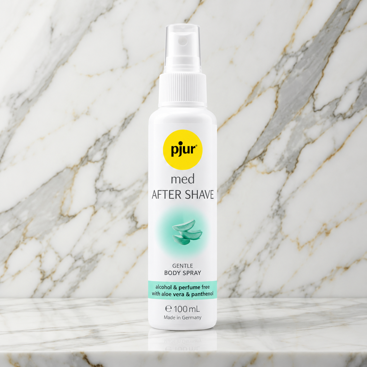 Witte sprayfles pjur med After Shave met geel logo op een marmeren plank