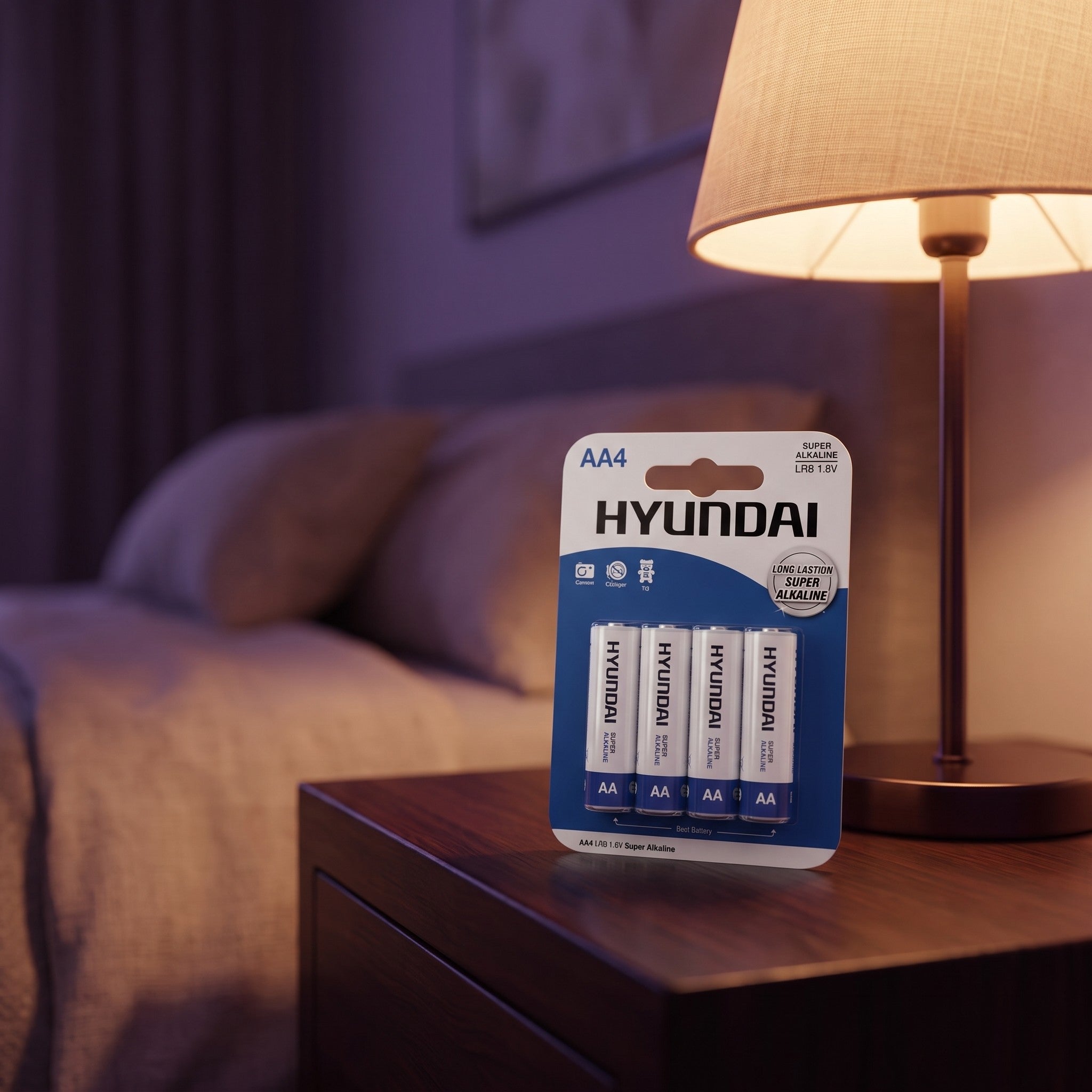Sfeerbeeld: vier AA-batterijen van Hyundai op een nachtkastje naast een lamp