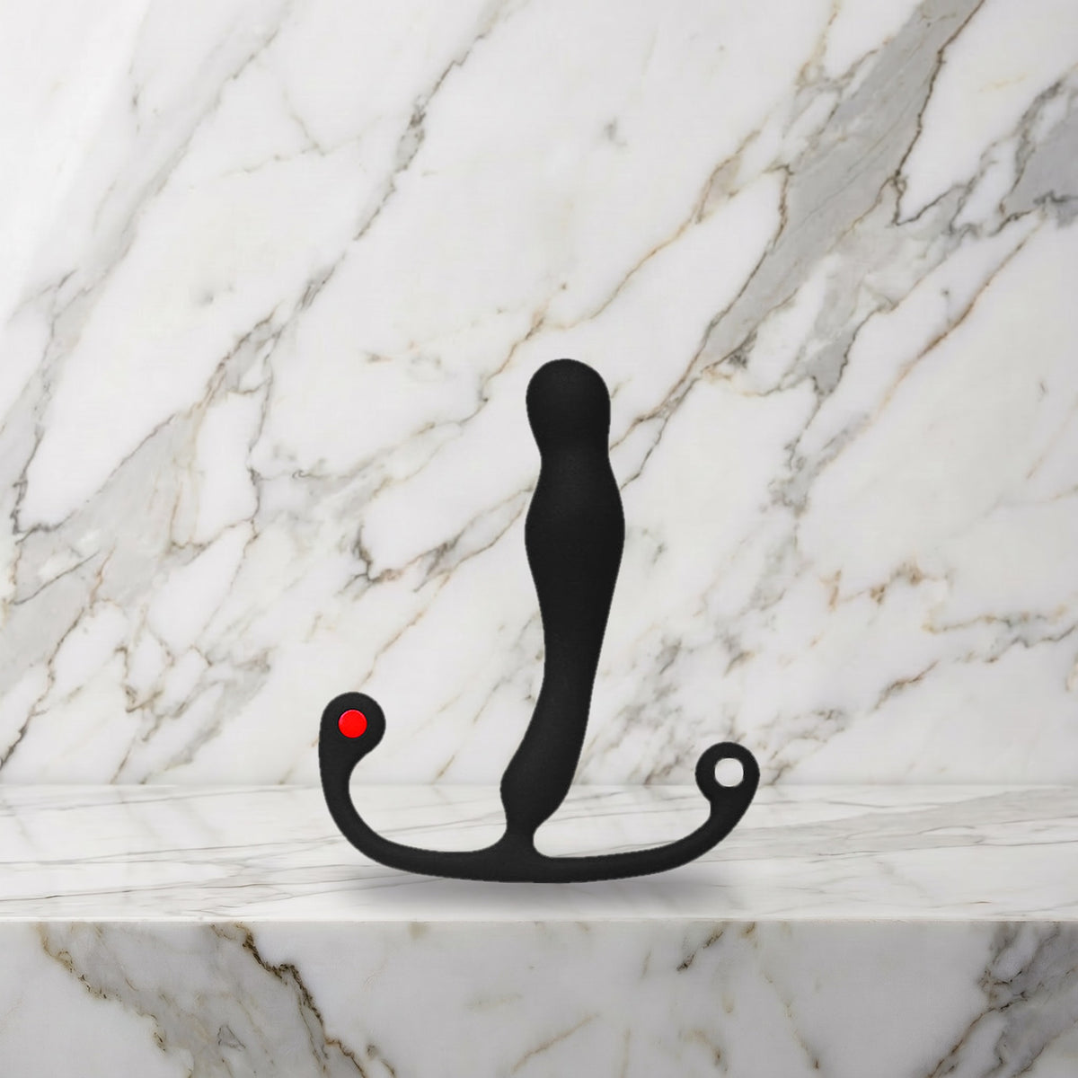 Zwarte smalle prostaatmassager met rood knopje op een marmeren plank, Aneros Eupho Syn