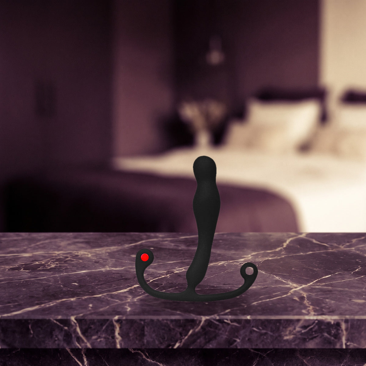 Sfeerbeeld: zwarte prostaatmassager Eupho Syn op donker marmer in een slaapkamer