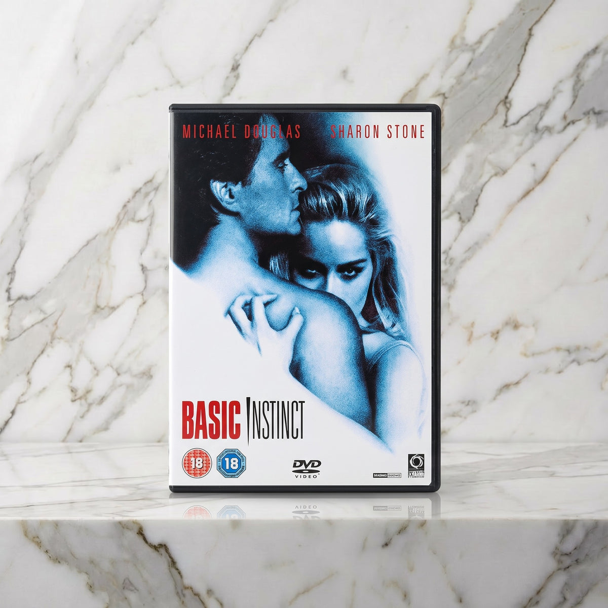 Dvd-hoes met Michael Douglas en Sharon Stone op een marmeren plank, Basic Instinct op dvd