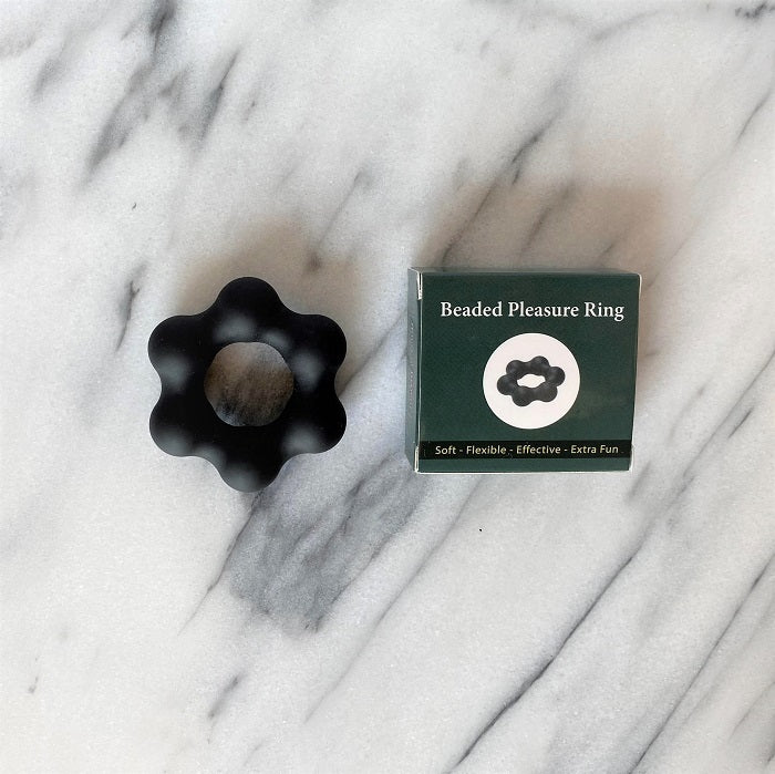 Zwarte Beaded Pleasure Ring met balletjes naast het groene doosje op marmer