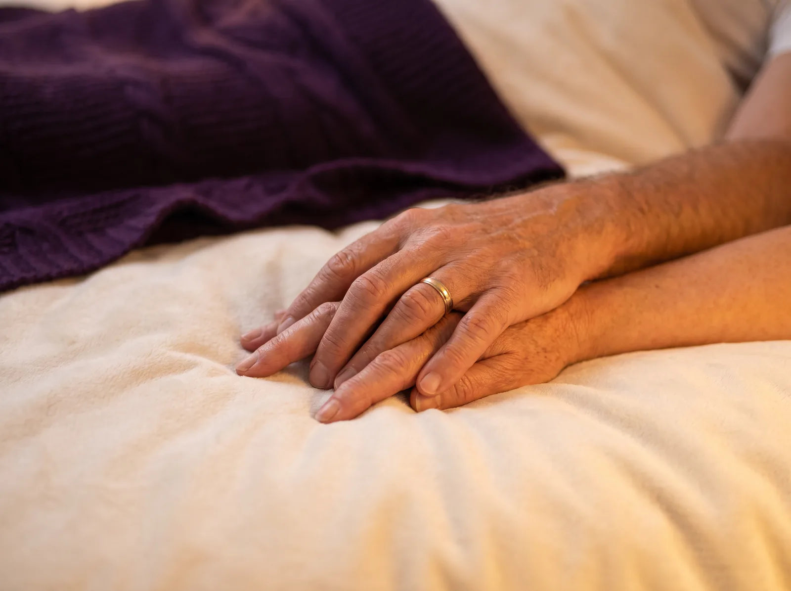 Sfeerbeeld: de hand van een man rust teder op de hand van zijn vrouw