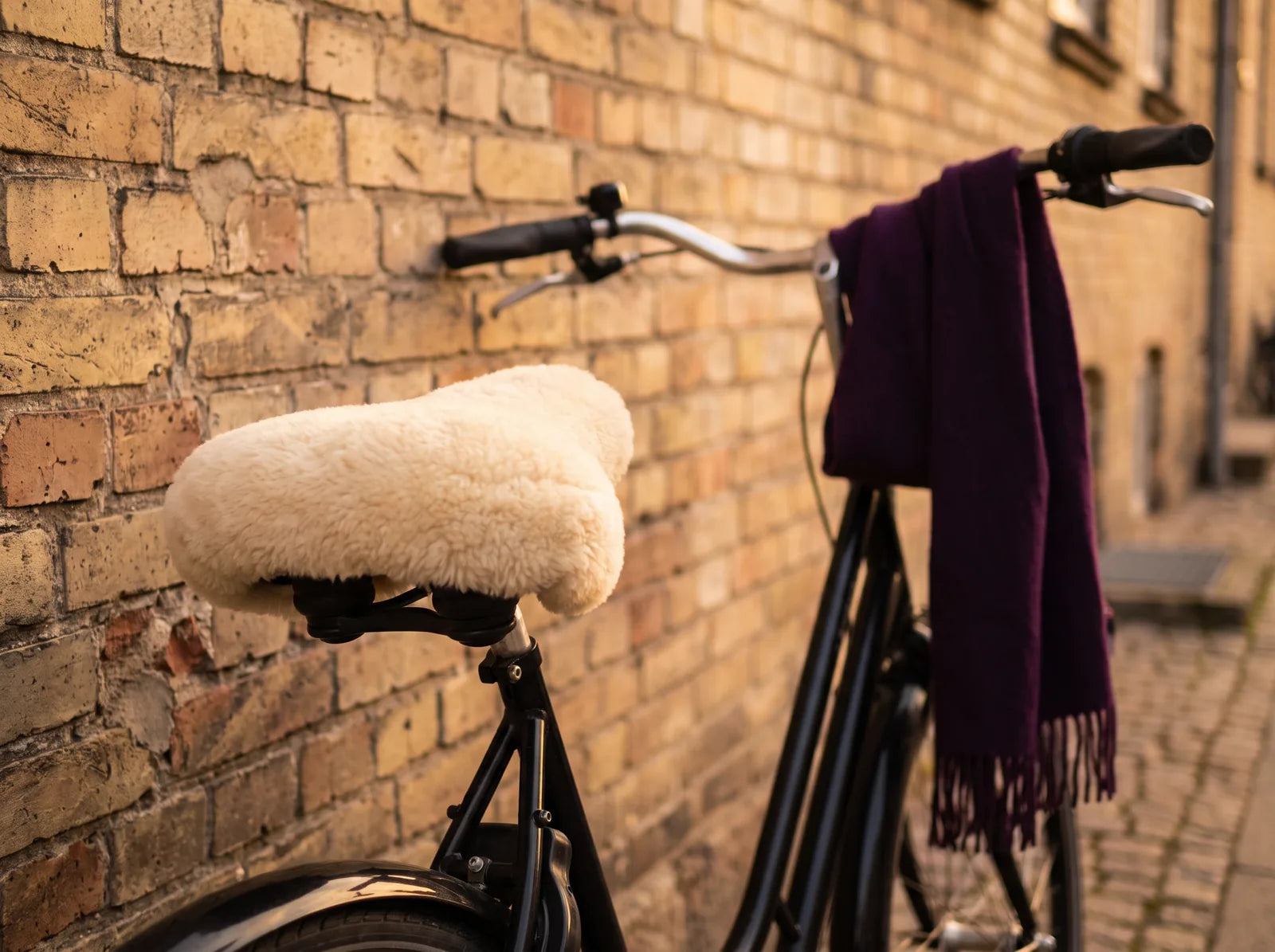 Sfeerbeeld: een fiets met een zachte zadelhoes van schapenvacht en een paarse sjaal