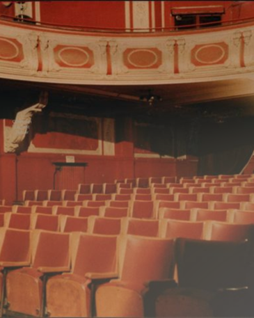 Klassieke theaterzaal Ciné Paris Brussel met rode fluwelen stoelen, sierlijk balkon en historisch interieur