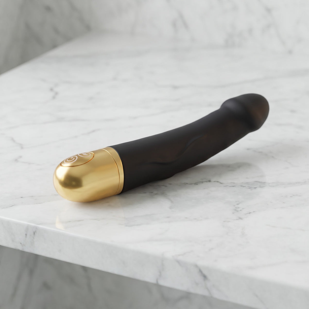 Zwarte semi-realistische vibrator met gouden onderkant op een marmeren plank, Dorcel Real Vibration M