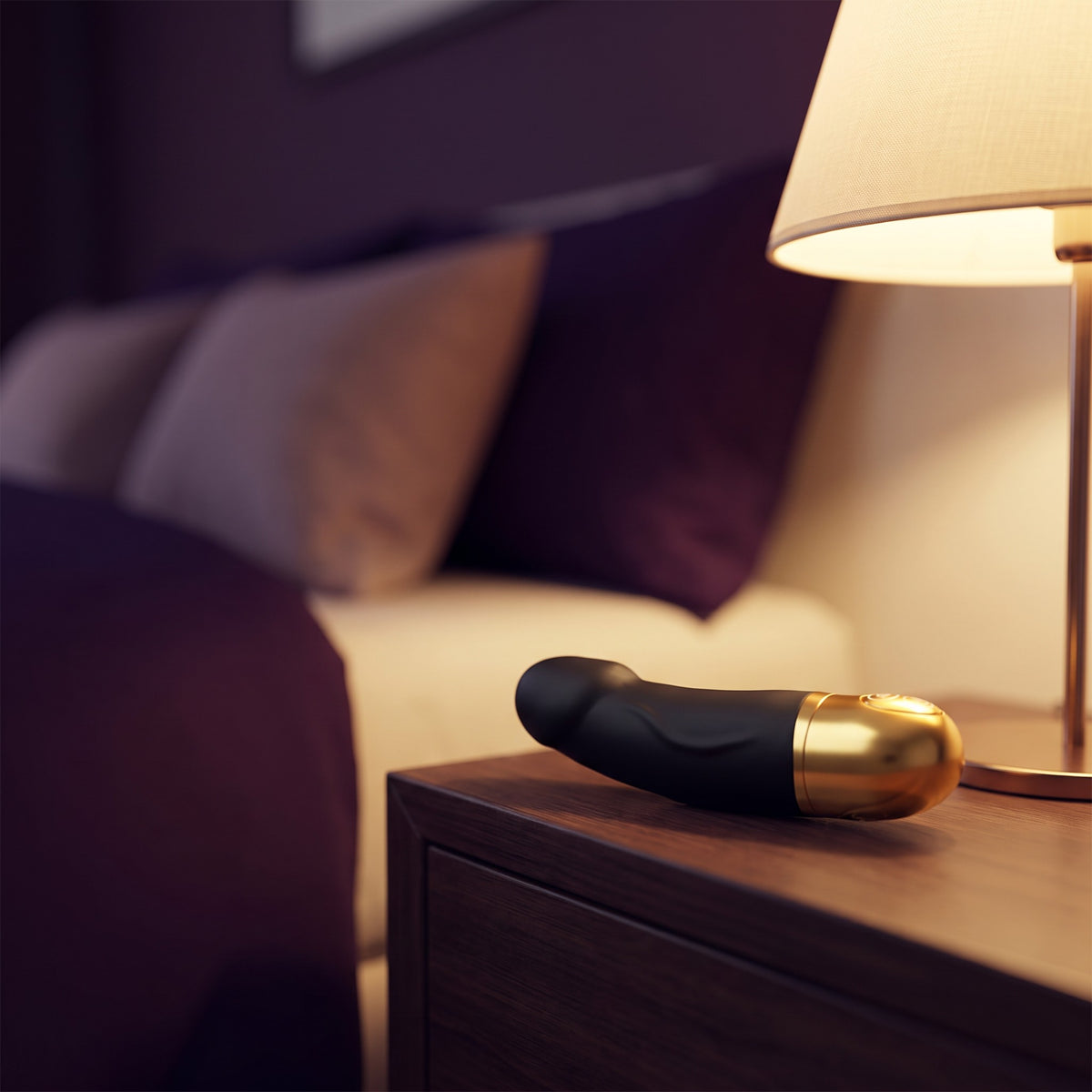 Sfeerbeeld: korte zwarte vibrator op een nachtkastje naast een brandende lamp, Dorcel Real Vibration S