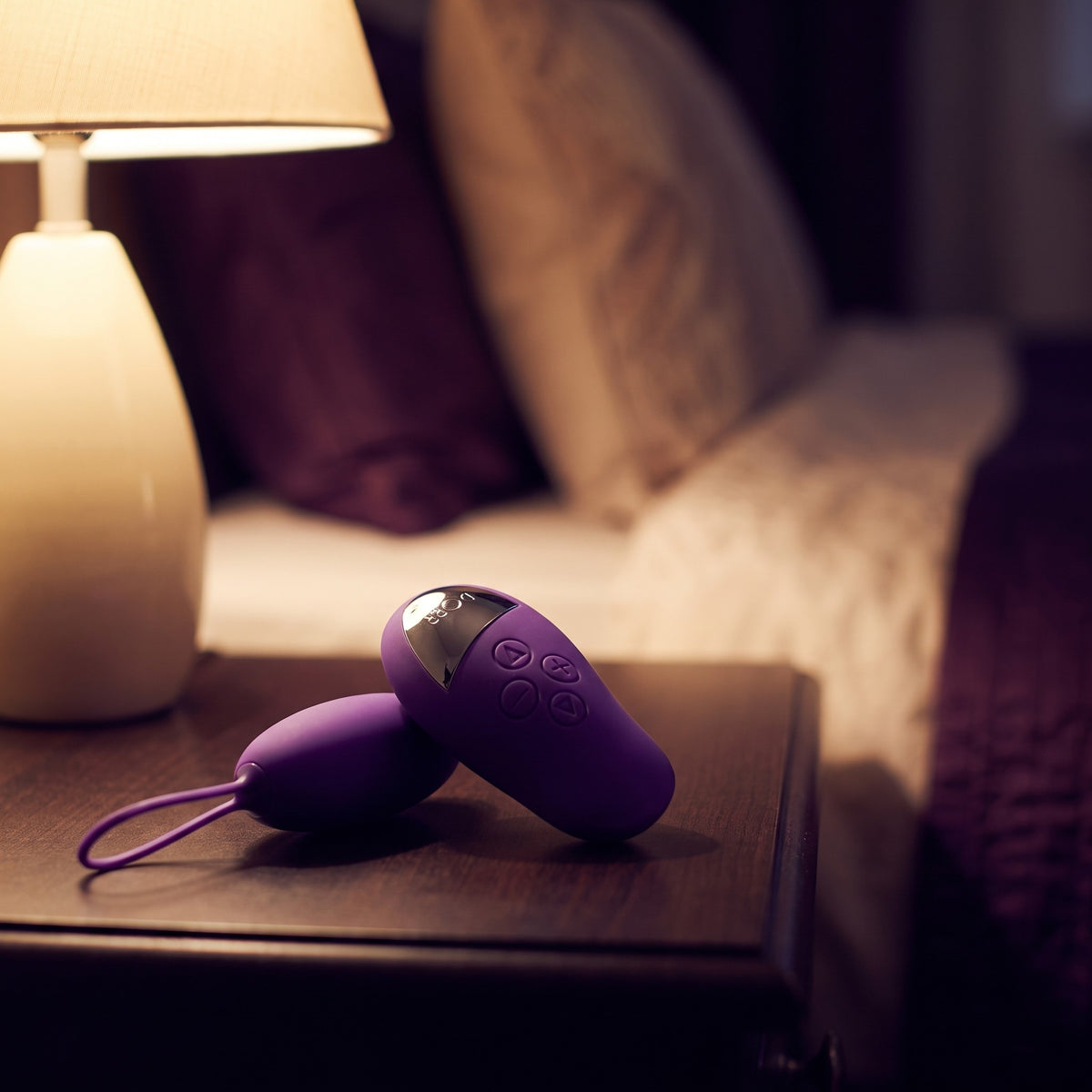 Sfeerbeeld: paarse Dorr Spot op een nachtkastje naast een brandende lamp