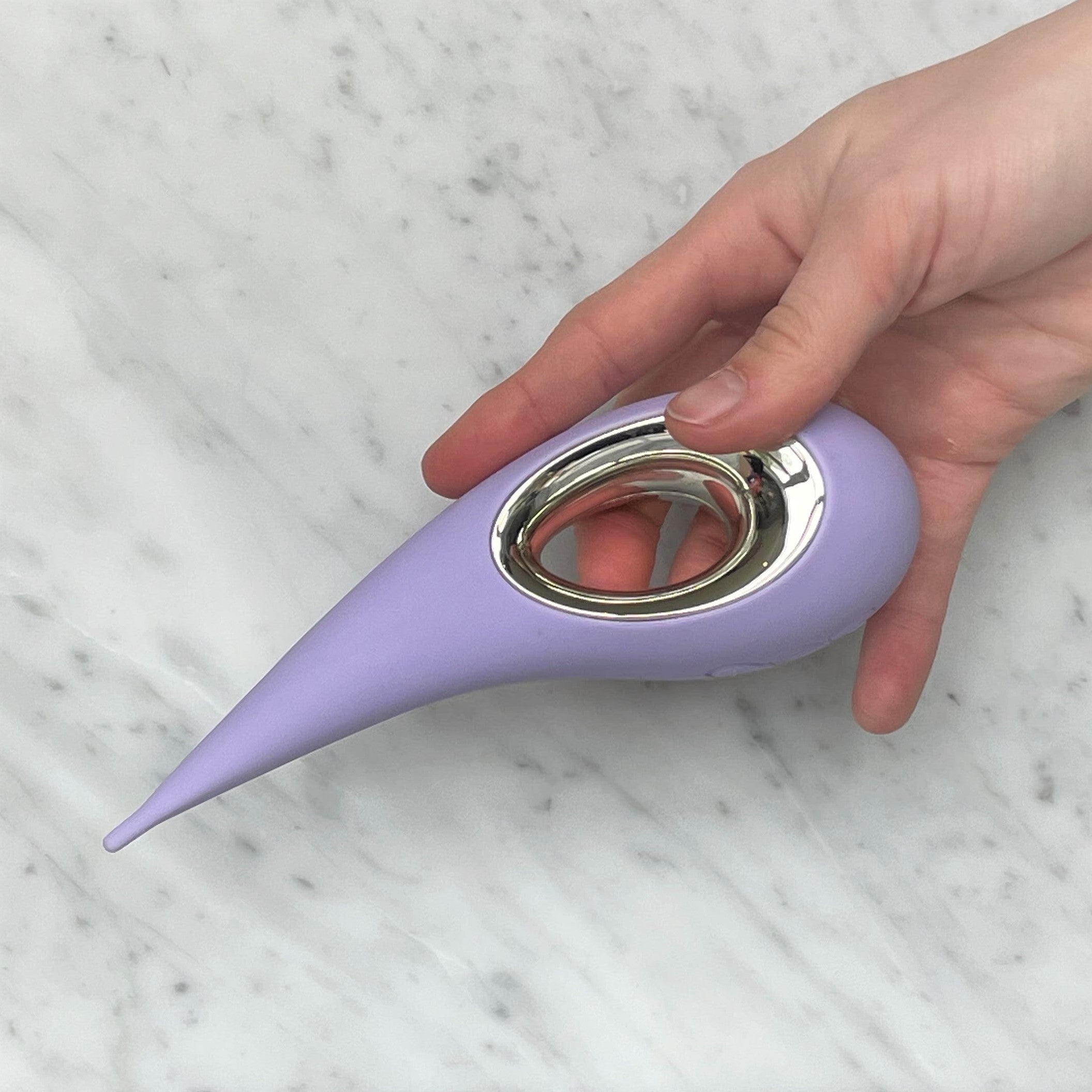 Dot clitorisstimulator van Lelo vastgehouden tussen vingers, alternatieve grip getoond