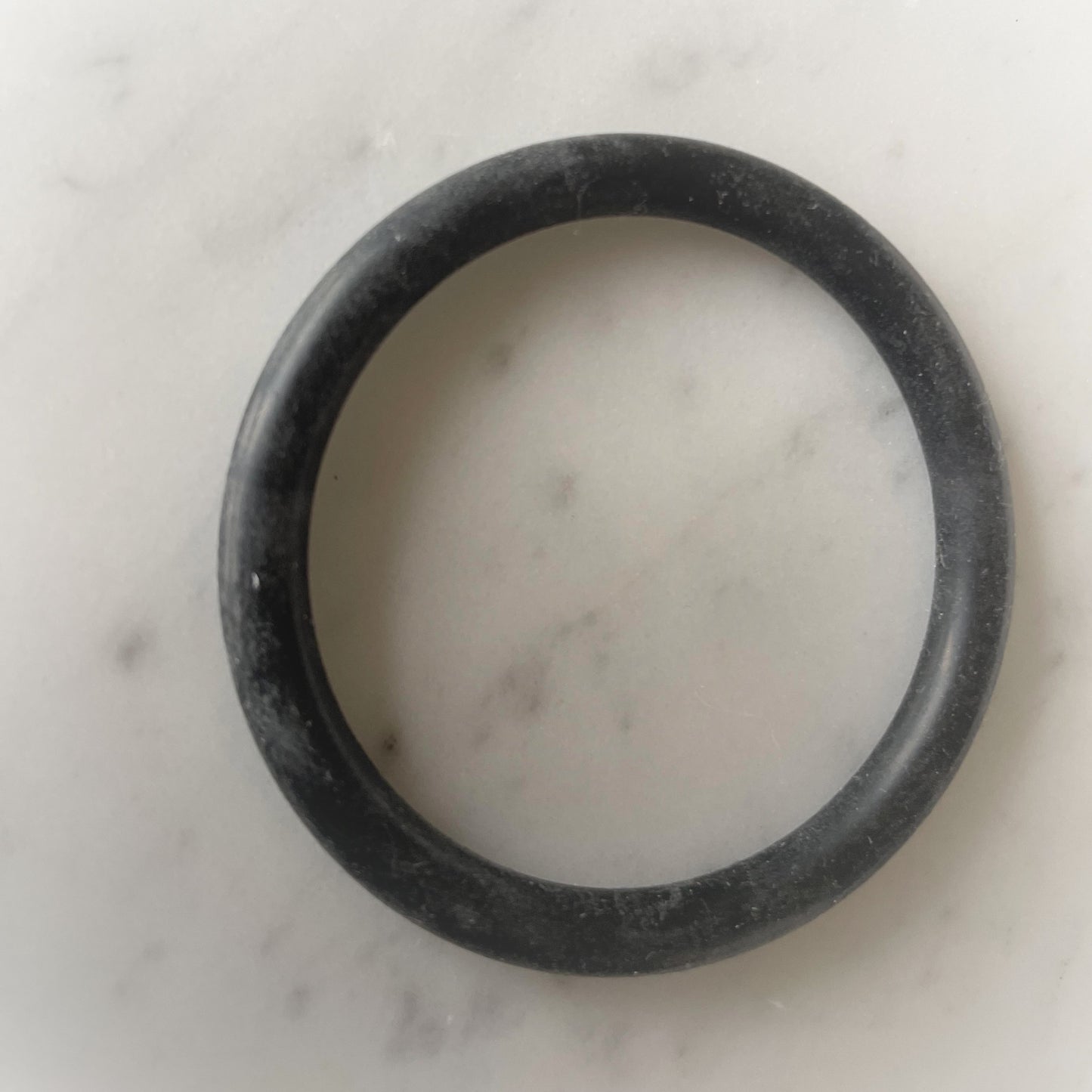 Zwarte dunne cockring close-up op marmeren ondergrond