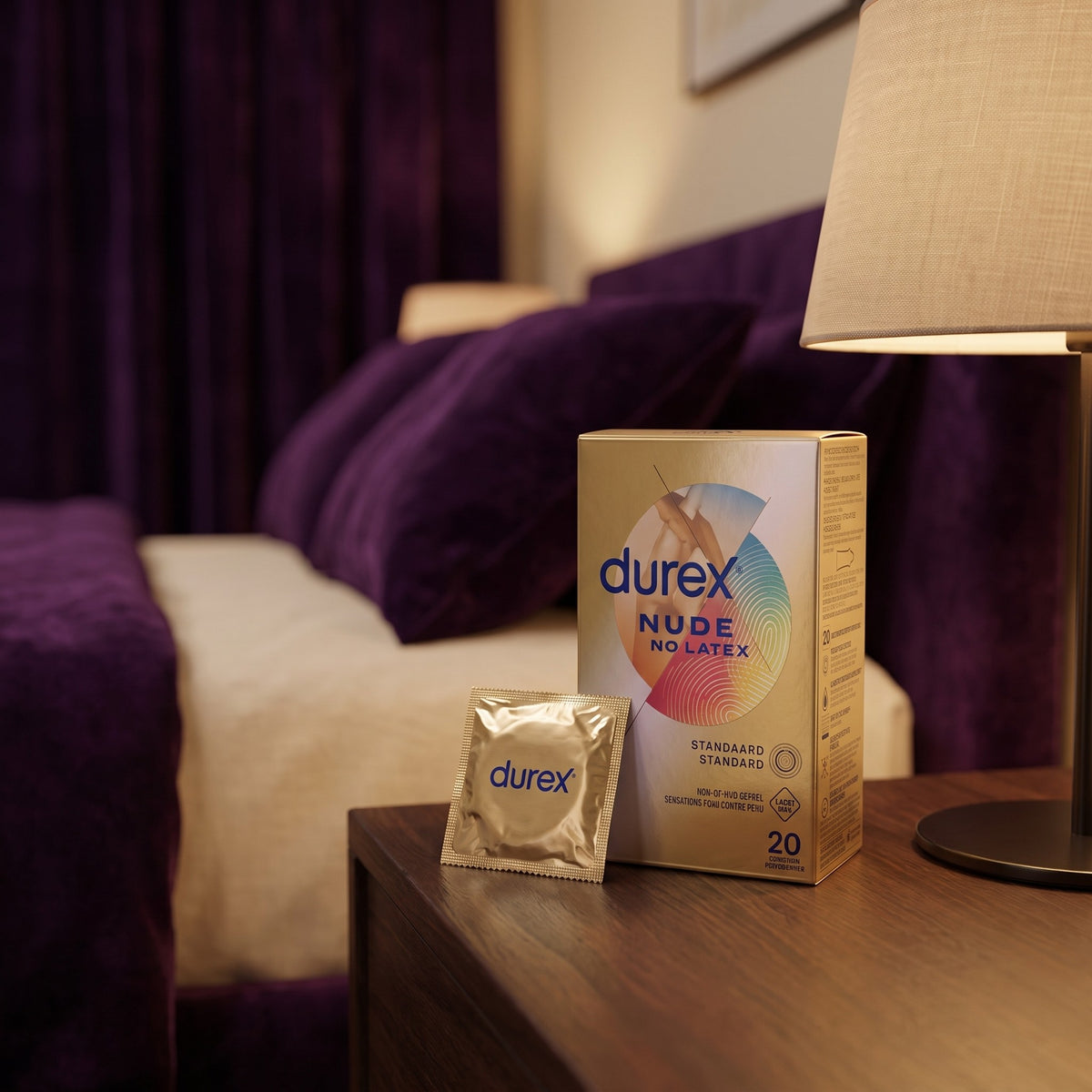 Sfeerbeeld: doos Durex Nude No Latex met zakje op een nachtkastje bij lamplicht