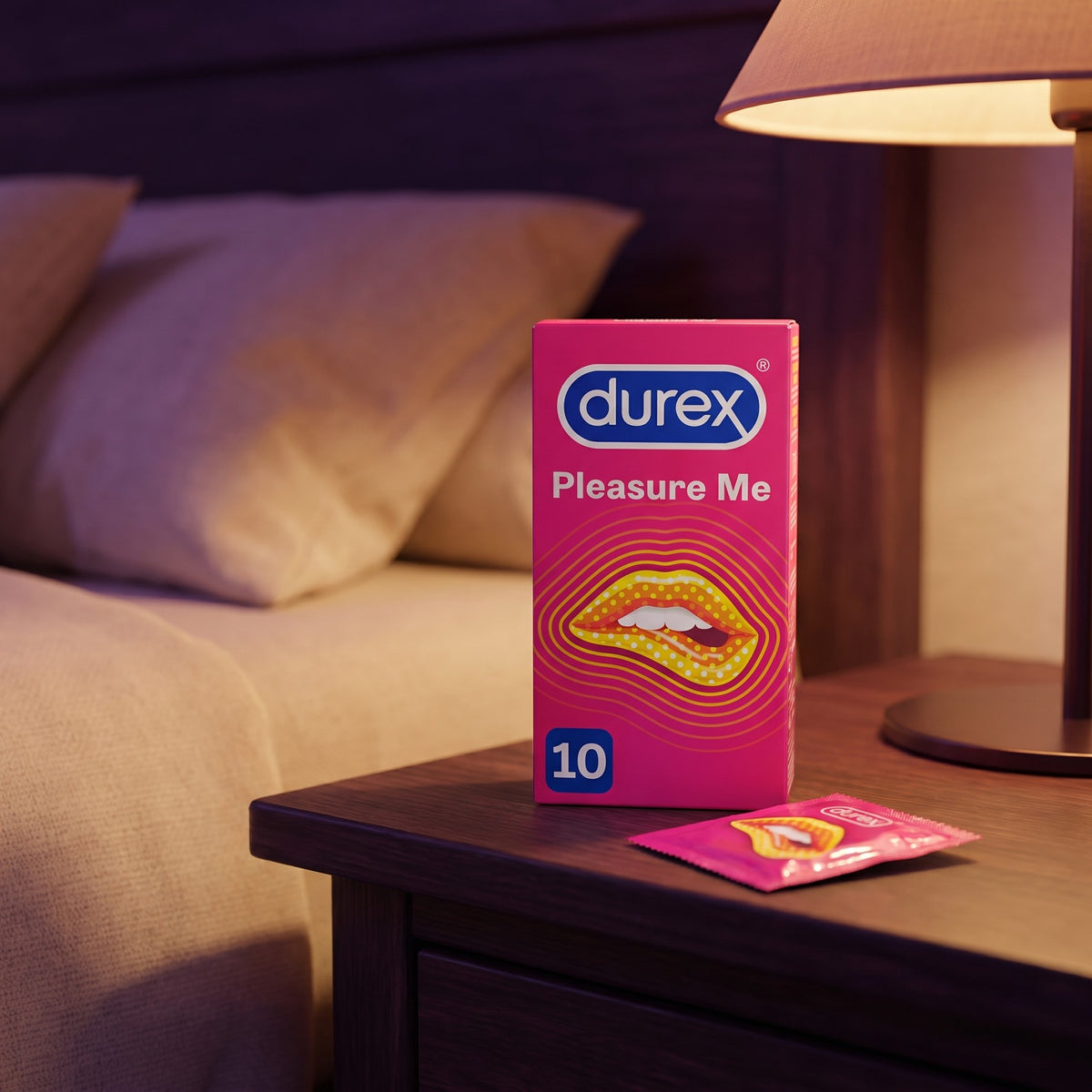 Sfeerbeeld: doosje Durex Pleasure Me condooms op een houten nachtkastje bij een brandende lamp
