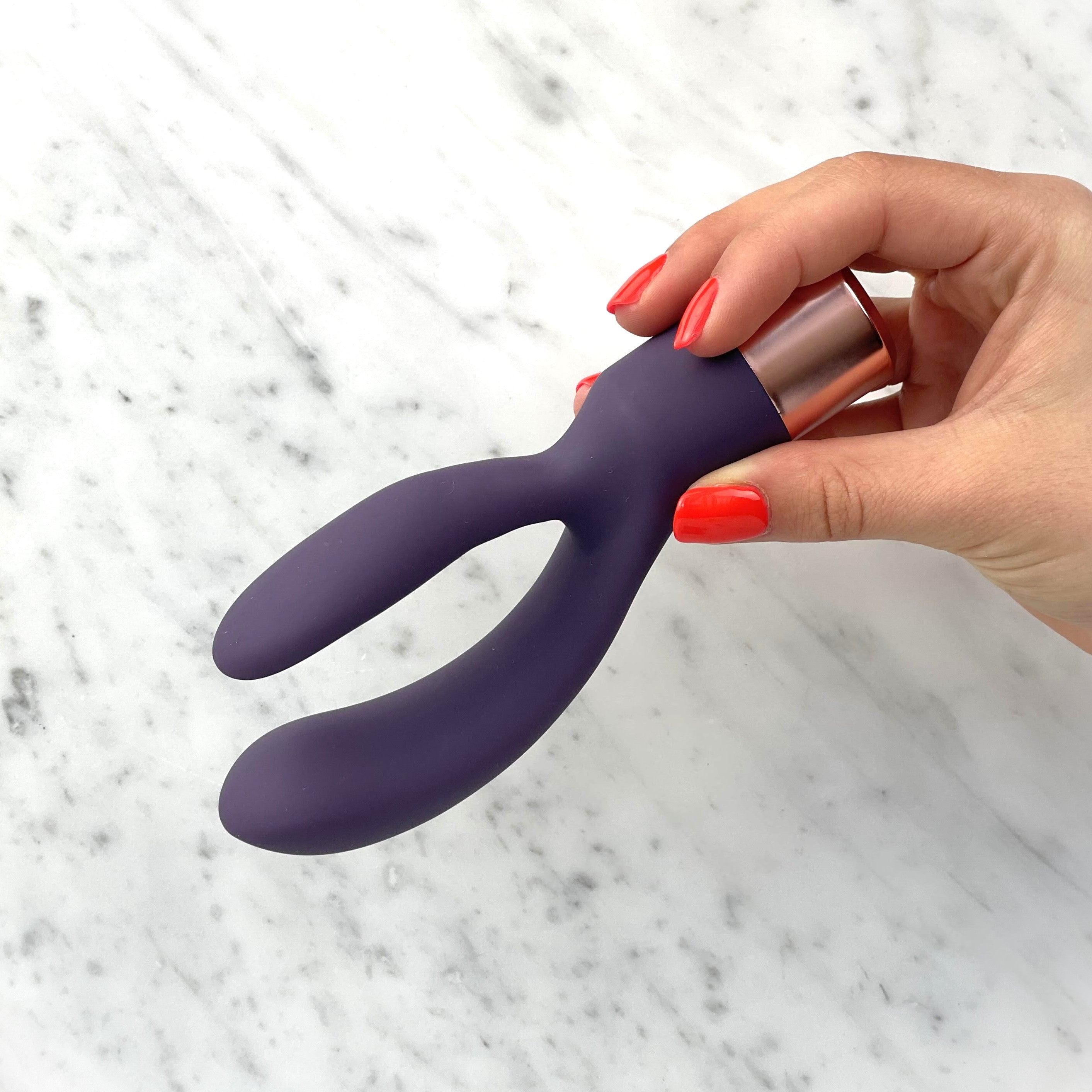 Hand houdt de buigzame Elegant rabbit vibrator vast bij de rose gouden kap, Orion