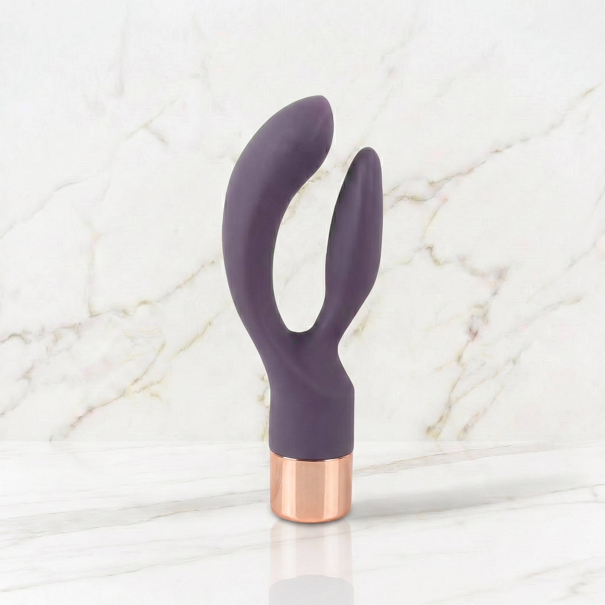 Slanke donkerpaarse rabbit vibrator met rose gouden kap op een marmeren plank, Elegant