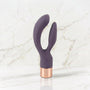 Slanke donkerpaarse rabbit vibrator met rose gouden kap op een marmeren plank, Elegant