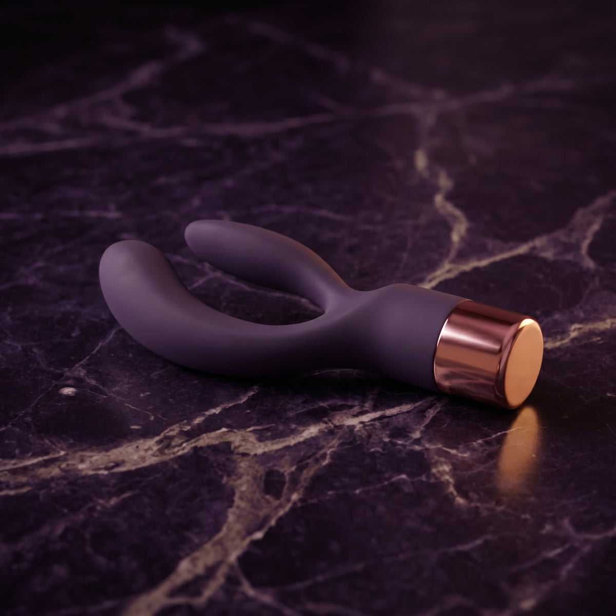 Sfeerbeeld: donkerpaarse rabbit vibrator Elegant liggend op donkerpaars marmer in gedempt licht