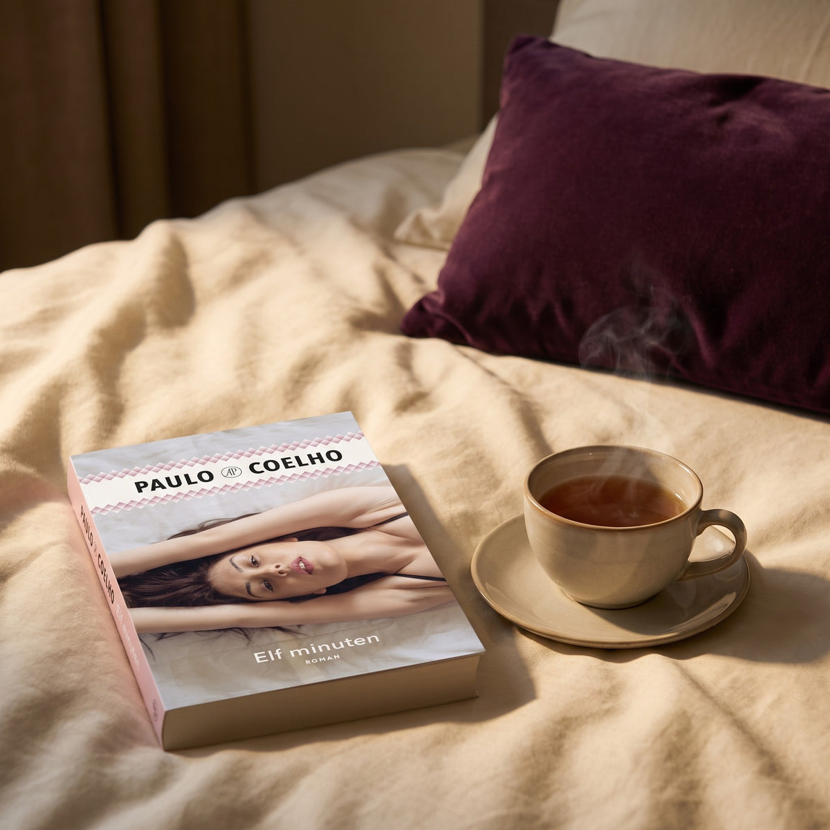 Sfeerbeeld: Elf minuten van Paulo Coelho op een bed naast een kop thee