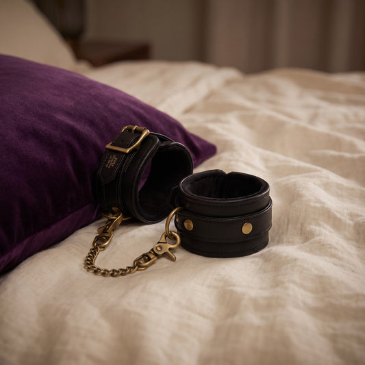 Sfeerbeeld: de enkelboeien op creme linnen naast een paars kussen, Fifty Shades of Grey