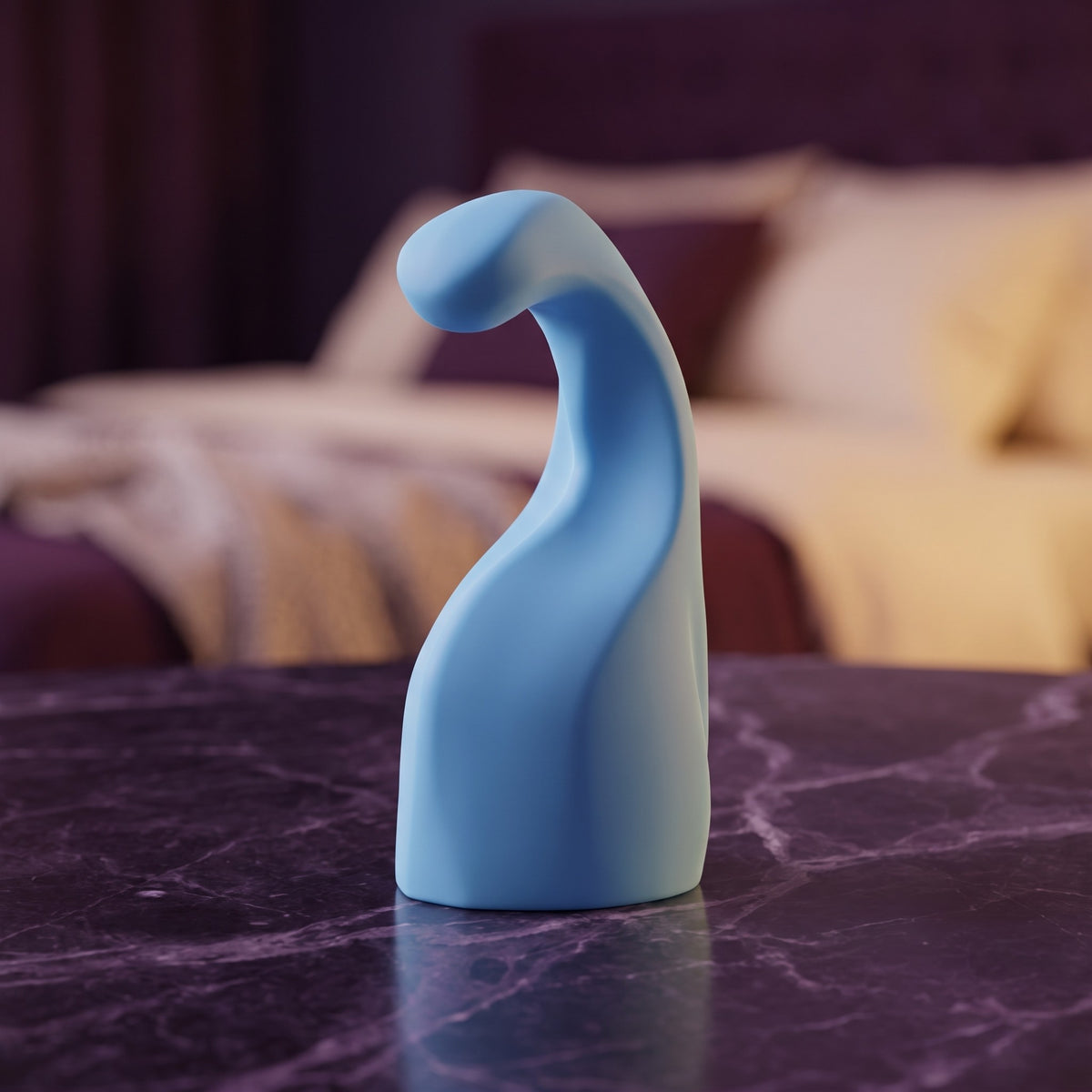 Sfeerbeeld: blauw Genius opzetstuk rechtop op donkerpaars marmer voor een bed in gedempt licht