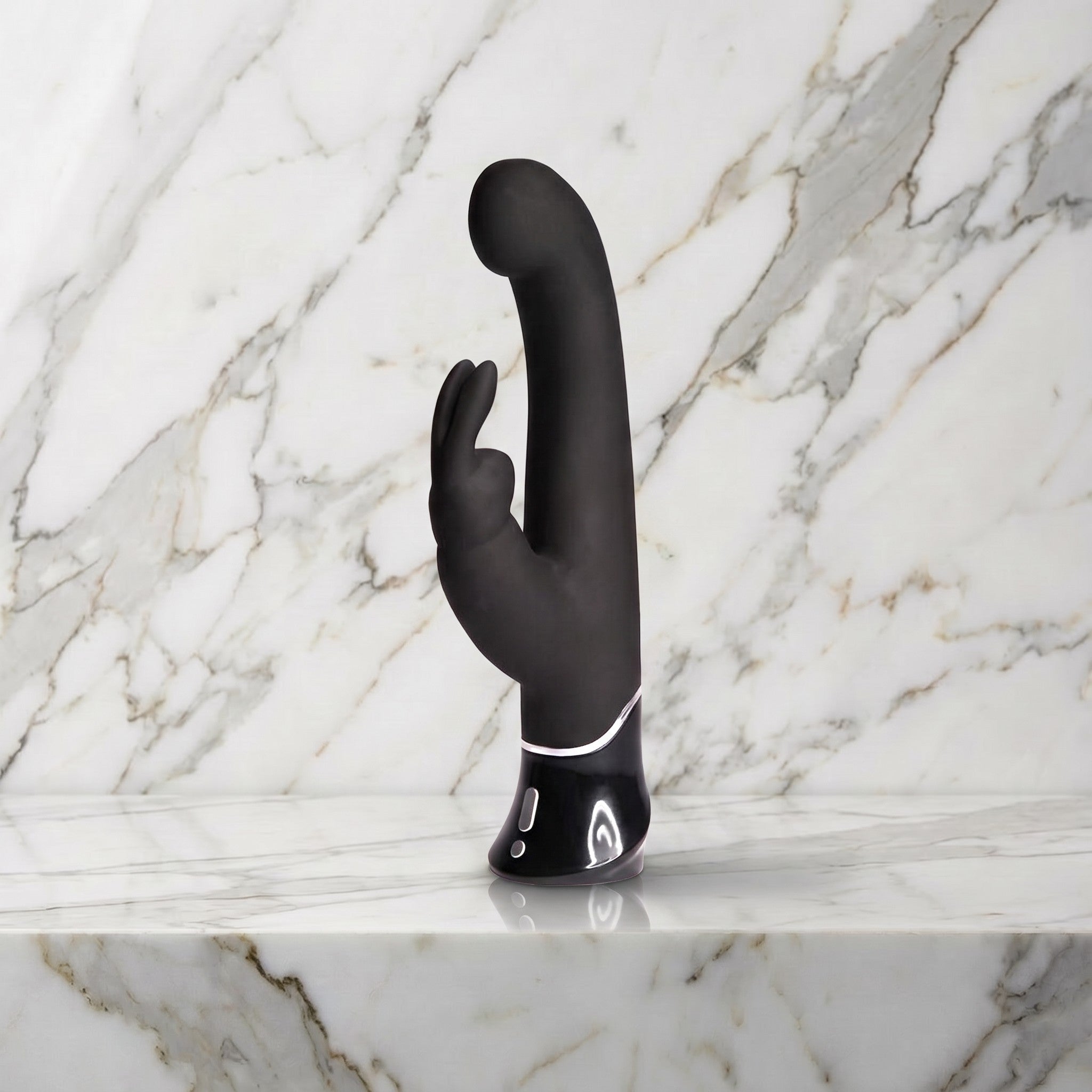 Zwarte Greedy Girl rabbit vibrator met gebogen kop en oortjes rechtop op een marmeren plank